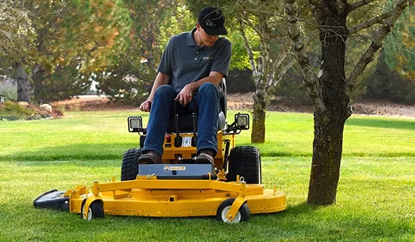 Walker ride-on mower cutting under trees